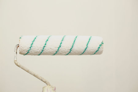 painting wall with paint roller. Painting apartment, renovating with white color paint. Room...
