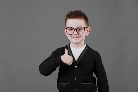 Little boy taking a picture using a retro camera and with finger pointed up. Child boy with vintage...