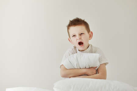 Little boy taking a picture using a retro camera and with finger pointed up. Child boy with vintage photo camera isolated on blue background. Old technology concept. Child learning photography.の写真素材
