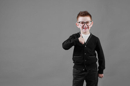 little schoolboy with ringing alarm clock is stretching and yawns, lazy going to school. blue...