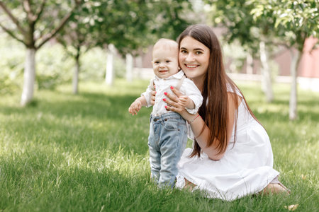 Happy beautiful woman, young mother playing with her adorable baby son, cute little boy, enjoying...