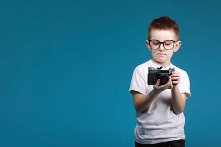 Like. Portrait of happy little schoolboy with glasses smiling at camera and doing thumbs up gesture, showing agree cool approval sign. indoor studio shot isolated on gray background.の写真素材