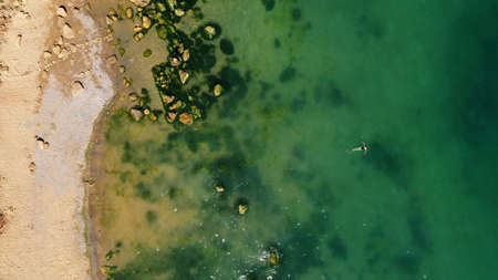 Dead Sea coastline in desert uninhabited extraterrestrial landscape aerial view. girl swims on the sea. lonely swimmerの写真素材