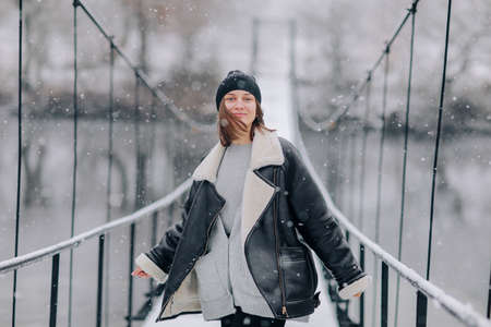 Studio portrait of attractive young woman with dark hair in white shirt and red pants sitting on classic chair on plain white background. Bossy female, job interview concept, confident independent lady.の写真素材