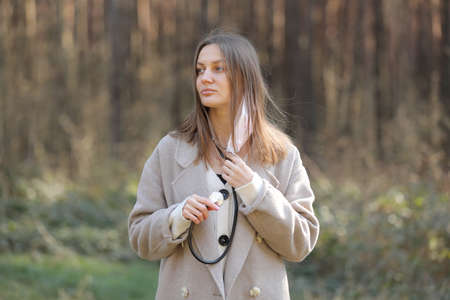 Studio portrait of attractive young woman with dark hair in white shirt and red pants sitting on classic chair on plain white background. Bossy female, job interview concept, confident independent lady.の写真素材
