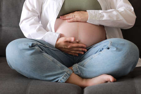 pregnant woman with big belly advanced pregnancy resting sitting on sofa at home.Healthy pregnancy and happy moterintyの写真素材