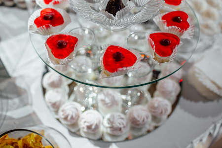 delicious candy bar at luxury wedding reception. exclusive expensive catering. table with modern desserts, cupcakes, sweets with fruits. baby or bridal shower. holiday celebration. selective focusの写真素材