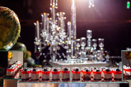 delicious candy bar at luxury wedding reception. exclusive expensive catering. table with modern desserts, cupcakes, sweets with fruits. baby or bridal shower. holiday celebration. selective focusの写真素材