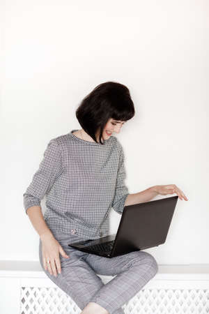 Pleasant talk with friend. Attractive young brunette woman talking on the phone. Technology, communication and coziness concept. girl emotionally talking on the phone at home.の写真素材