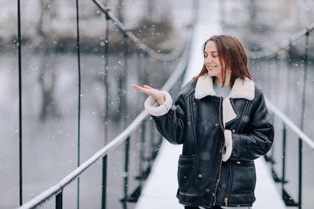 Studio portrait of attractive young woman with dark hair in white shirt and red pants sitting on classic chair on plain white background. Bossy female, job interview concept, confident independent lady.の写真素材