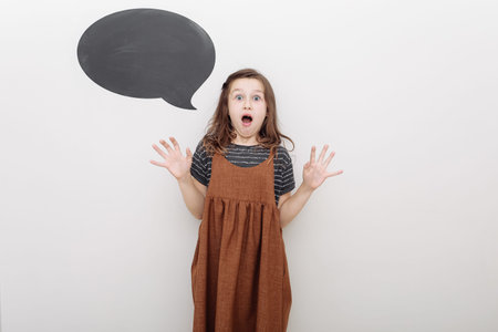 portrait emotional 7 year old girl on white background. baby girl shows the emotion of fun. mock up...