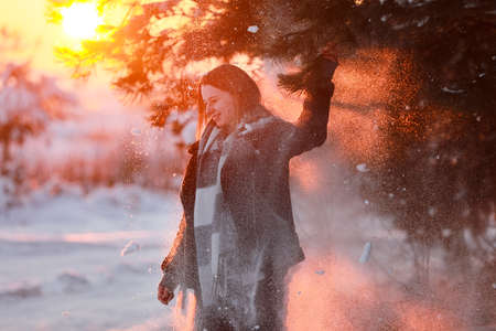 Young beautiful woman with short hair, in checkered shirt walking in snowy forest. winter holiday.の写真素材