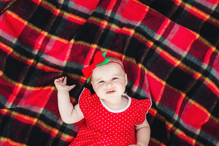 Cute 10 months baby girl on picnic on grass with watermelons. child in red dress and bow on head....