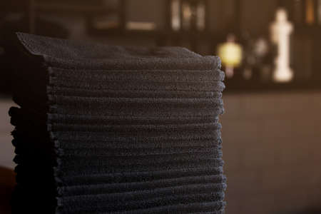 stacked black bathroom towels in spa salon, barbershopの写真素材