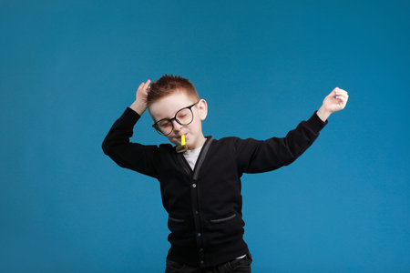 happy easter kids. Boy in rabbit bunny ears on head with colored egg on blue background. Cheerful...