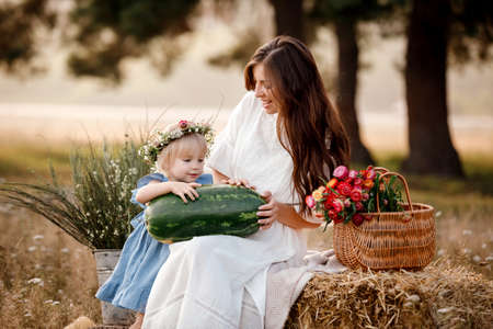 Mom And Little Daughter Enjoying Family Picnic Eating Watermelon Sitting On Blanket In Beautiful summer Park. Weekend With Mother Concept.の写真素材
