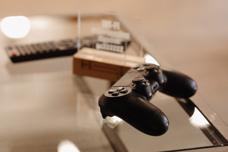 video game controller on glass table. gaming, technology and entertainment concept - blue gamepad...