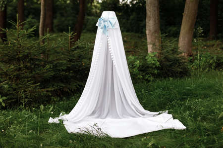 white children's wigwam,tent with a blanket in a green summer sunny garden.の写真素材