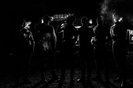 dark silhouettes of a men Smoking a cigarettes on a night street.の写真素材