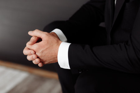 Close up of male clasped hands clenched together, businessman preparing for job interview,...