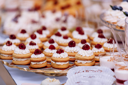Wedding candy bar table. Cakes with cream and berries and other sweets. High quality photo.