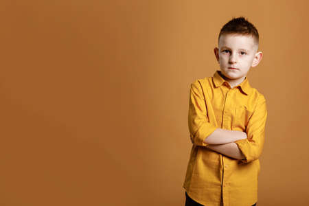 Shopping on black friday. Little boy holding shopping bags on yellow background. Shopper with many colored paper bags. Holiday sales and discounts. Cyber Monday. High quality photo.の写真素材