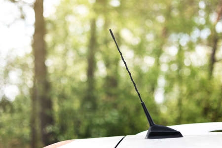 green forest behind car antenna.Car antenna for receive the radio waves on roof car. Selective focus and close up.の写真素材