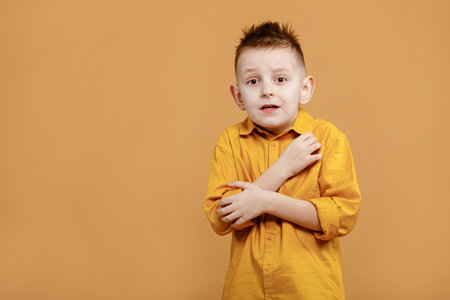 portrait of caucasian scared child boy on yellow background. amazed stressed boy in yellow shirt. school child afraid or shocked. surprised kid with fear and excited face. good and bad news.の写真素材