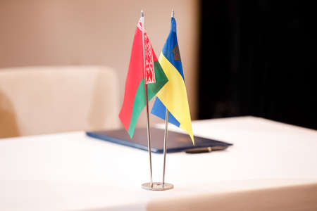 red green national flag of Belarus and blue yellow flag of Ukraine. Minsk ceasefire talks between Ukraine and Russia. Symbol of Belarusian-Ukrainian friendshipの写真素材