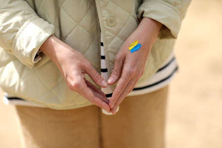 stop war. Peace in Ukraine. woman with picture of flag of ukraine on hand. Antiwar support concept. high quality photoの写真素材