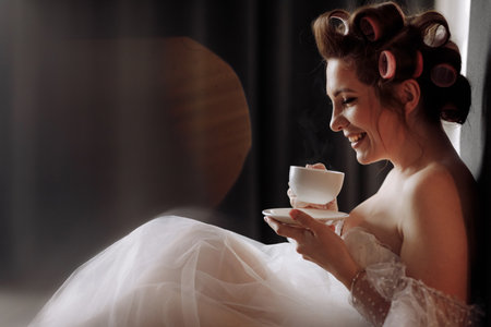 stylish young woman in white t shirt, jeans and red jacket and shoes on high heels is sitting on red ladder. studio short.の写真素材