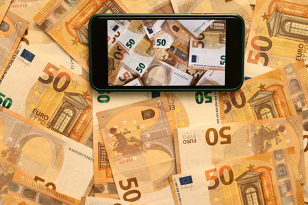 Money paper 50 euro banknotes on the background of a smartphone screen, the concept of business,...