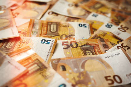 50 Euro money currency banknotes background with lighting. European paper money backdrop with 50 euro bills. Financial investment, savings, income earnings conceptの写真素材