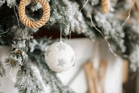 Fir branch decorated with Scandinavian style Christmas white ball and natural baubles. Christmas...