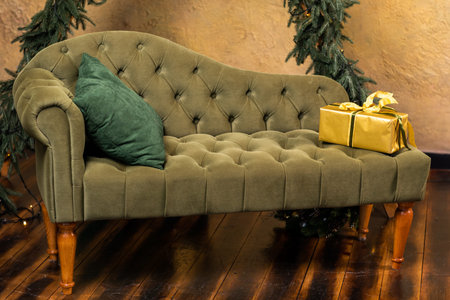 Christmas composition with decoration, christmas tree branch, stylish green classic sofa, gift boxes...