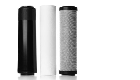 Filter cartridges for house water filtration system on white background. Foamed polypropylene, granular and briquettes carbon cartridges. Installation of reverse osmosis water purification systemの写真素材
