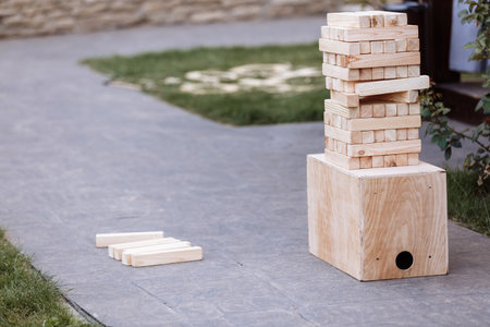 multistory tower of wooden blocks. Group game of physical skill with big blocks for outdoors, vertical. Game for children and adults.の写真素材