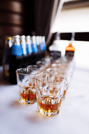 a lot of glasses with cognac, brandy or whiskey stand on the bar. Various alcoholic beverages in...