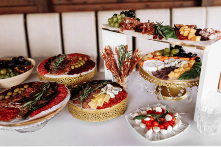 Appetizers table with meat and cheese. Salami, sausages, variation of cheese, grapes, tomatoes,...