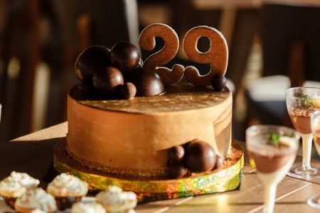candy bar. Delicious sweet buffet with brown birthday cake decorated with chocolate balls and number...