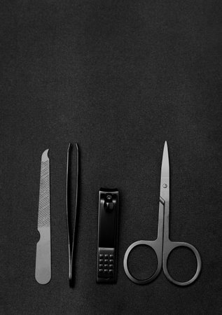 Stylish set of stainless manicure and pedicure tools isolated on black background. Classic metal kit of nail scissors, tweezer and manicure tools. Domestic nail beauty care objects. individual device.の写真素材
