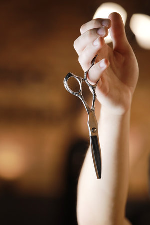 Barbershop. Hairdresser's hand is holding two different types of scissors. barber professional tools. Male haircut, fashion. Hair salon, hair cut and shaving background. small business. selective focus.の写真素材