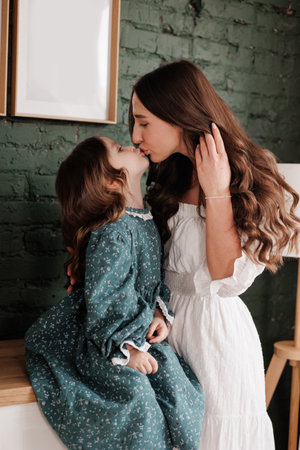 mother's day. Sensitive young mom embraces her little adorable daughter at home. Trust, support and love between mommy and child. Loving family enjoy tender sweet moments and tight hugs. children day.の写真素材