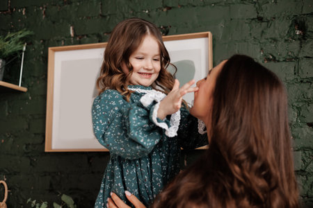 Mothers day. Sensitive young mom embraces her little adorable daughter at home. Trust, support and love between mommy and child. Loving family enjoy tender sweet moments and tight hugs. Children day.の写真素材