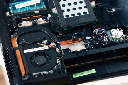 Fixing laptop. Repairman holds cooling fan and repairs from overheating. Disassembling computer,...