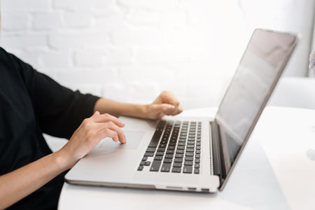 Close up woman's hands typing on laptop keyboard at home office. Businesswoman or student girl using pc for online internet marketing, freelance, work from home, education online, distance studying.の写真素材