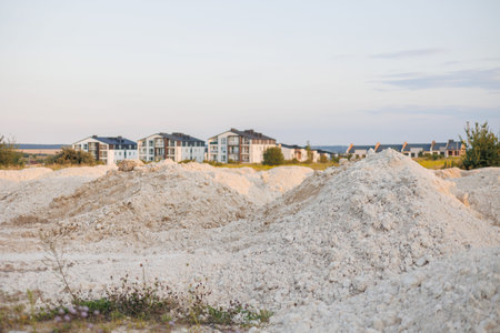 Construction site with mound of sand and soil. Preparation for building multi-apartment residential complex. Construction Materials. Beginning of work on creation of houses. New housing concept.の写真素材