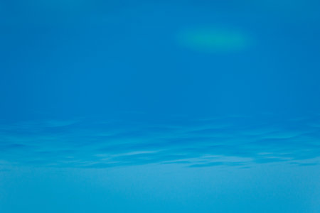 Out of focus of blue water background. Close up surface of blue gradient texture in swimming pool. Waves in clear water. Abstract backdrop liquid for wallpaper or cover of summertime. Pattern textureの写真素材