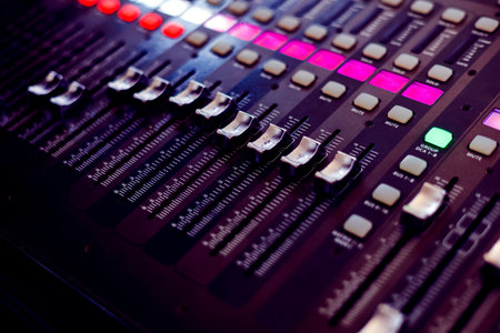 Concert sound mixer panel with volume regulators. Professional audio and light equipment for sound recording studio, live music broadcasting, television, party. mixing console. audio signals.の写真素材