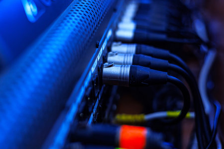 Rear console of control panel for equipment with connection cables to connect the equalizer, amplifier, microphones, speakers and other musical instruments. Connections of professional sound system.の写真素材